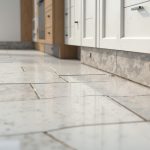 Pose de plinthes carrelage dans une cuisine moderne avec différents matériaux.