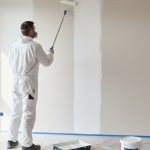 Artisan appliquant une sous-couche sur un mur intérieur pour une finition professionnelle.