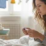 Femme regardant un test de grossesse négatif avec confusion et inquiétude.